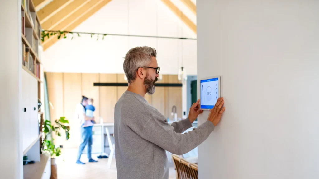 mężczyzna obsługujący panel sterowania smart home